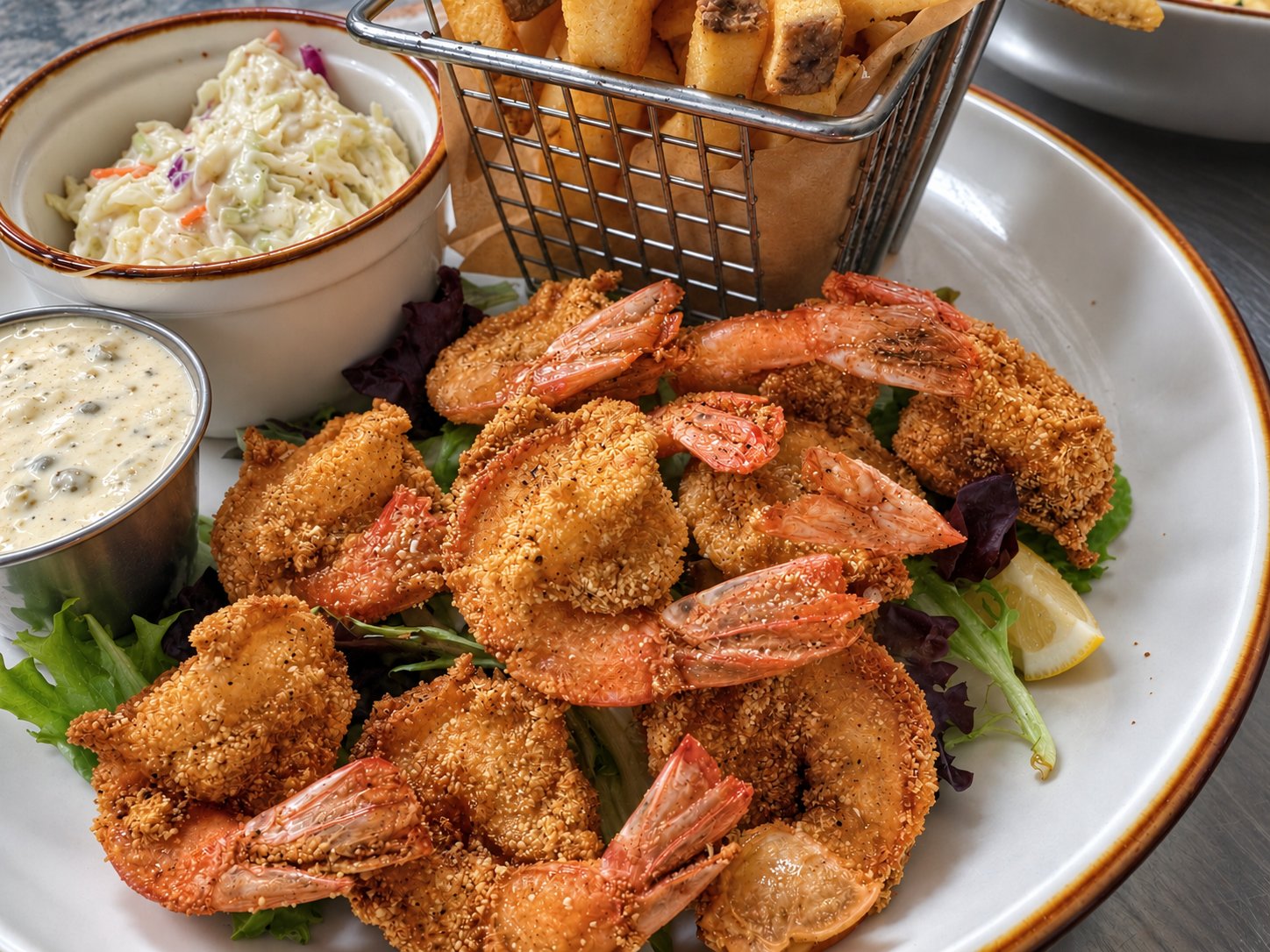 Fried shrimp plate with fries, coleslaw and a lemon wedge